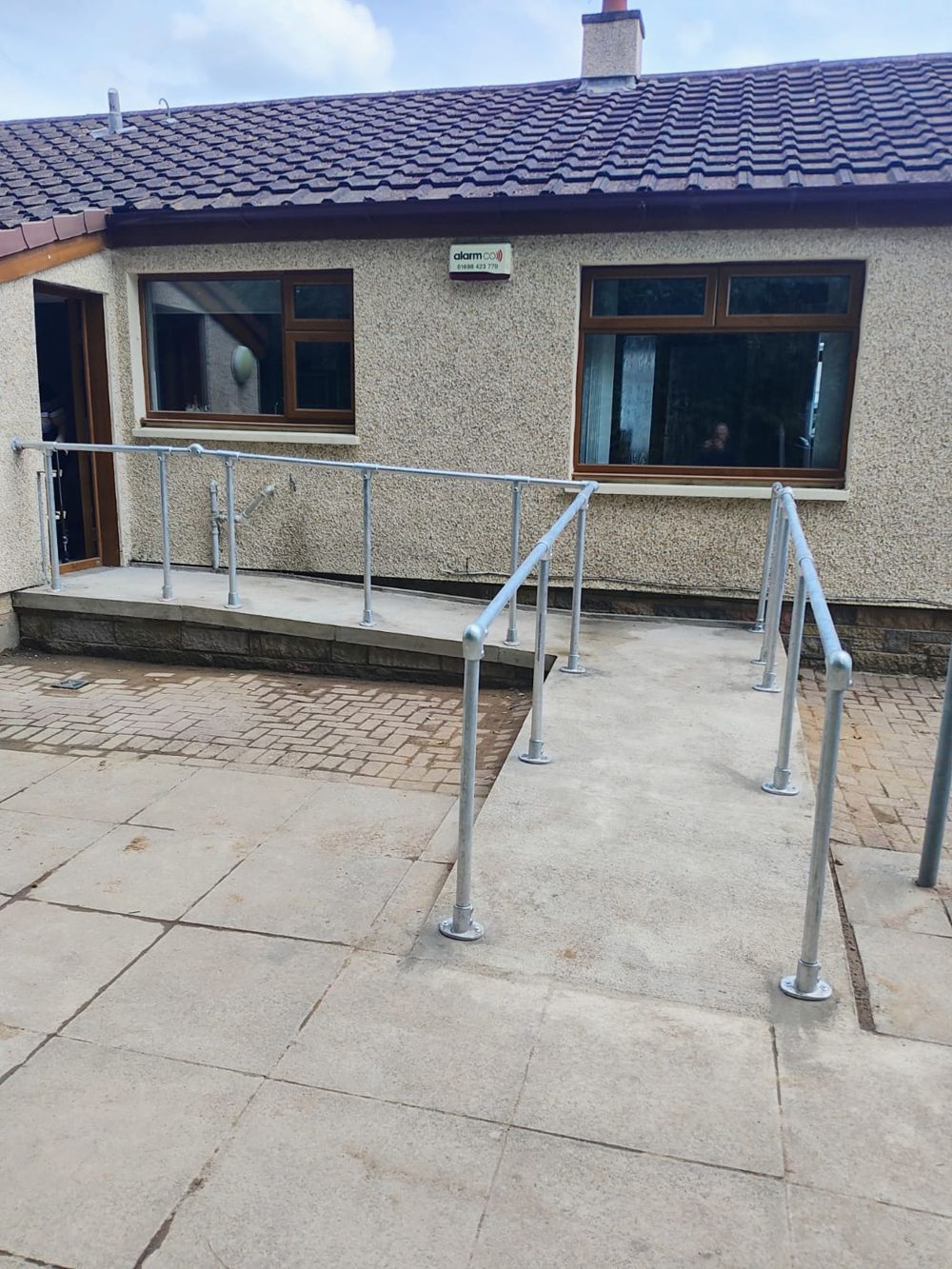 Completed concrete rear access ramp with galvanised handrails